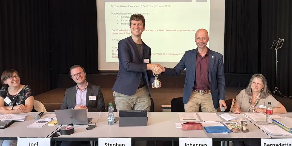 Der abtretende EOV-Präsident Johannes Reinhard übergibt die EOV-Glocke an der DV 2026 in Rapperswil an seinen Nachfolger Stephan Matter.
