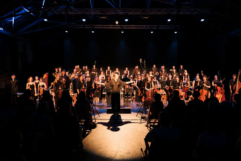 Das Orchestra Giovane mit der Dirigentin Solveig Lindroos im Sommer 2026 nach dem Konzert in der Grossen Halle der Reitschule in Bern.